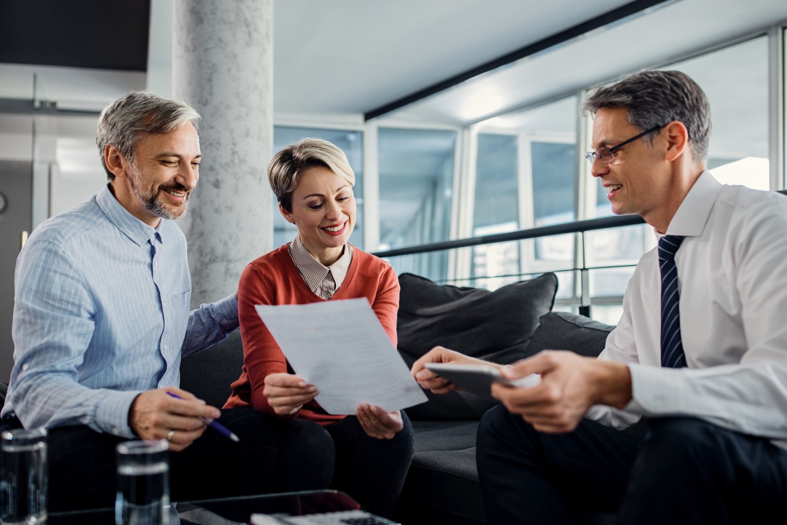 happy couple and financial advisor going through plans during th